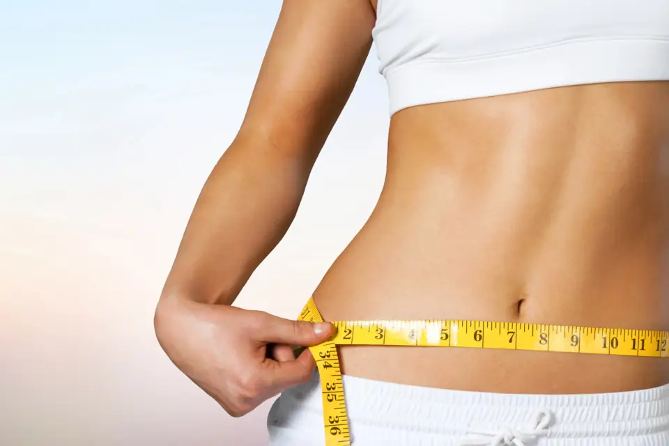 Person measuring waist with tape measure